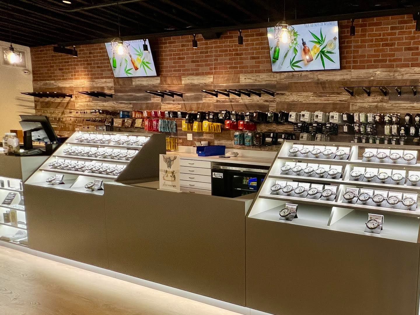 Storefront with shelves and monitors, showcasing sleek dispensary displays and design