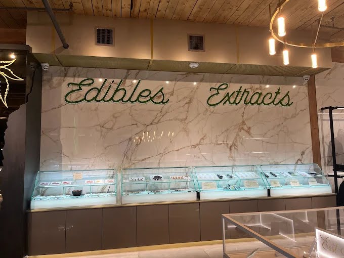 Mother Earth Dab Bar Cabinet displaying cannabis edibles and extracts in a modern retail store environment